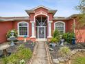Front entrance showcases columns, arched windows and artful landscaping at 5100 Lockhart Rd, Brooksville, FL 34602