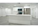 Modern kitchen with stainless steel appliances, a large island, and white cabinets at 5510 12Th St, Zephyrhills, FL 33542