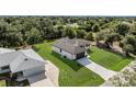 An aerial view reveals a cozy home with a river at the back and driveway at the front, surrounded by lush greenery at 7054 Rosemont Dr, Englewood, FL 34224