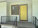 Inviting front entrance with a bright yellow door and classic black railings at 708 Keeling St, Brooksville, FL 34601