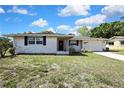 Charming single Gathering home with a brick facade, driveway, and front yard landscaping at 7810 Pineapple Ln, Port Richey, FL 34668