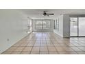 Spacious living room featuring tile floors, ceiling fan, and natural light at 7810 Pineapple Ln, Port Richey, FL 34668