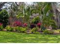 Manicured garden featuring lush tropical greenery, including ferns and bromeliads, bordering the property at 8260 32Nd N Ave, St Petersburg, FL 33710