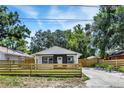Cozy single-story house featuring a fenced yard, fresh exterior paint, and a private driveway at 8603 N 9Th St, Tampa, FL 33604