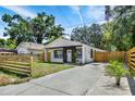 Attractive single-Gathering home enhanced by a neatly maintained lawn, a new fence, and lush landscaping at 8603 N 9Th St, Tampa, FL 33604