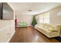 Cozy living room with hardwood floors, a decorative Christmas tree, and large windows at 9020 Gray Fox Ln, Port Richey, FL 34668