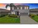 Charming two-story home features a well-manicured lawn, lush landscaping, and a two-car garage at 1022 Montgomery Bell Rd, Wesley Chapel, FL 33543