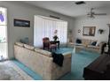 Bright living room featuring floral sofas, blue carpet, and a large window with sheer curtains at 10400 112Th Way, Largo, FL 33778