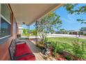 Cozy covered porch with seating, bird bath, and lush landscaping offering curb appeal at 11348 59Th Ter, Seminole, FL 33772