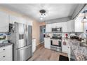 Bright kitchen with stainless steel appliances, granite counters, and modern white cabinets at 11348 59Th Ter, Seminole, FL 33772