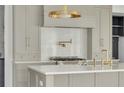 Modern kitchen features gray cabinets, white countertops, marble backsplash, and brass hardware at 116 24Th S Ave, St Petersburg, FL 33705
