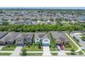 A high aerial view displays a sprawling neighborhood with lush greenery and a serene pond nearby at 1203 Custer Bayou Street, Ruskin, FL 33570