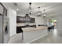 Spacious kitchen featuring dark wood cabinets, stainless steel appliances, and a large center island at 1203 Custer Bayou Street, Ruskin, FL 33570