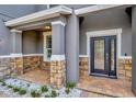 Welcoming front porch with stone accents, detailed front door, and tiled flooring, offering curb appeal at 1229 Hillandale Reserve Dr, Tampa, FL 33613