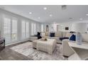 Spacious living room with stylish furnishings, plantation shutters, and a decorative rug adding warmth to the gray floors at 1263 Overcash Dr, Dunedin, FL 34698
