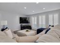 Cozy living room featuring a large sectional sofa, plantation shutters, and recessed lighting for a bright, inviting space at 1263 Overcash Dr, Dunedin, FL 34698