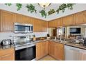 Cozy kitchen with wood cabinets, stainless steel appliances, and granite countertops at 12925 Fieldmoor Ct, Riverview, FL 33579