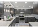 Modern kitchen featuring gray cabinets, stainless steel appliances, and a mosaic backsplash at 16076 Dawnview Dr, Tampa, FL 33624