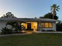 Inviting home exterior with a well-manicured lawn and mature palm trees in a tranquil setting at 1775 62Nd S Ter, St Petersburg, FL 33712