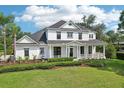 Charming two-story home with a welcoming wrap-around porch and beautifully landscaped front yard at 19803 Prince Benjamin Dr, Lutz, FL 33549