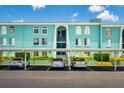 A view of the aqua building with a parking spot for each unit, and lush greenery surrounding the building at 255 114Th N Ave # 4, St Petersburg, FL 33716