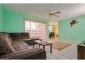 A view of the living room with a brown sectional sofa, a ceiling fan and a dining room is visible at 255 114Th N Ave # 4, St Petersburg, FL 33716
