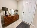 Inviting foyer features a stylish console table with decorative lamps and a round mirror above at 2717 Chestnut Creek Pl, Brandon, FL 33510