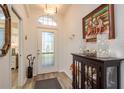 Inviting front foyer with decorative glass door, wood floors, and elegant furnishings at 2747 Wood Pointe Dr, Holiday, FL 34691