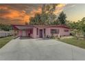 Charming pink one-story home featuring a covered carport and well-maintained landscaping at 3104 W Powhatan Ave, Tampa, FL 33614