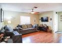 Well-lit living room with comfortable seating, a ceiling fan, and a mounted television at 3139 W Varn Ave, Tampa, FL 33611