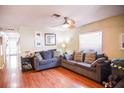 A bright living room with a ceiling fan, wood floors, and comfortable seating at 3139 W Varn Ave, Tampa, FL 33611