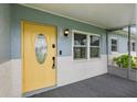 Inviting front porch with a bright yellow door and textured brick detail at 4230 Indianapolis Ne St, St Petersburg, FL 33703