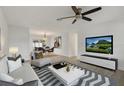 Bright living room features sleek furnishings, modern decor, and a ceiling fan, offering a comfortable and stylish space at 4230 Indianapolis Ne St, St Petersburg, FL 33703