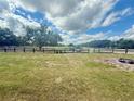 Scenic horse property with lush green pasture and fencing under a bright, cloudy sky at 439 Corbett Rd, Lithia, FL 33547