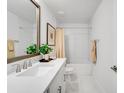 Bright bathroom featuring white cabinetry, marble floors, and shower/tub combo at 4511 S Manhattan Ave # 11, Tampa, FL 33611