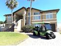 Beautiful two-story home with a grand staircase, lush landscaping, and convenient golf cart parking at 514 Harbor N Dr, Indian Rocks Beach, FL 33785