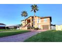 Inviting two-story home featuring a well-manicured lawn and paved driveway leading to an attached garage at 514 Harbor N Dr, Indian Rocks Beach, FL 33785
