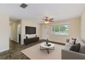 Bright and airy living room featuring a large window, neutral tones, and a comfortable seating arrangement at 521 E Lumsden Rd, Brandon, FL 33511