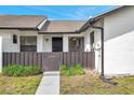 Charming front entrance features secure front entry with a dark brown fence and blue skies at 5306 Marlwood Ct, Tampa, FL 33624