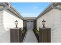 Inviting front entrance with stylish gray double doors and decorative lighting fixtures at 6240 Keller Dr, Port Richey, FL 34668