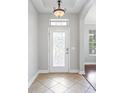Warm foyer with decorative tile flooring, elegant lighting fixture and decorative glass front door at 7725 Tangle Rush Dr, Gibsonton, FL 33534