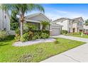 Beautiful front yard with lush landscaping, including palm trees, hedges, and manicured lawn at 7725 Tangle Rush Dr, Gibsonton, FL 33534