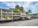 Condominium building with covered parking, multiple stories, balconies, and well manicured grounds at 920 Virginia St # 109, Dunedin, FL 34698