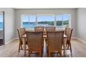 Cozy dining area with a waterfront view, complete with a wooden table and six woven chairs at 100 Bluff View Dr # 404C, Belleair Bluffs, FL 33770