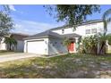 View of the exterior of a two-story home featuring a red front door at 10337 River Bream Dr, Riverview, FL 33569
