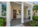 Charming front porch with wood door, stylish lighting, and manicured landscaping at 12 Country Club Ln, Belleair, FL 33756