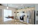 Bright kitchen featuring granite countertops, stainless steel appliances, and custom cabinets with designer hardware at 12808 Killarney Ct, Odessa, FL 33556