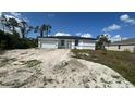 A single-story house sits on a property undergoing landscaping work, surrounded by a mix of sandy soil and fresh grass at 13266 Drysdale Ave, Port Charlotte, FL 33981