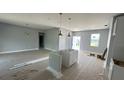 An open-concept living space is in progress with gray walls, modern lighting, and a base for a kitchen island at 13266 Drysdale Ave, Port Charlotte, FL 33981