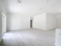 Spacious, bright living area with light-colored wood floors and fresh white walls, awaiting personalization at 16134 Libourn Ave, Port Charlotte, FL 33954